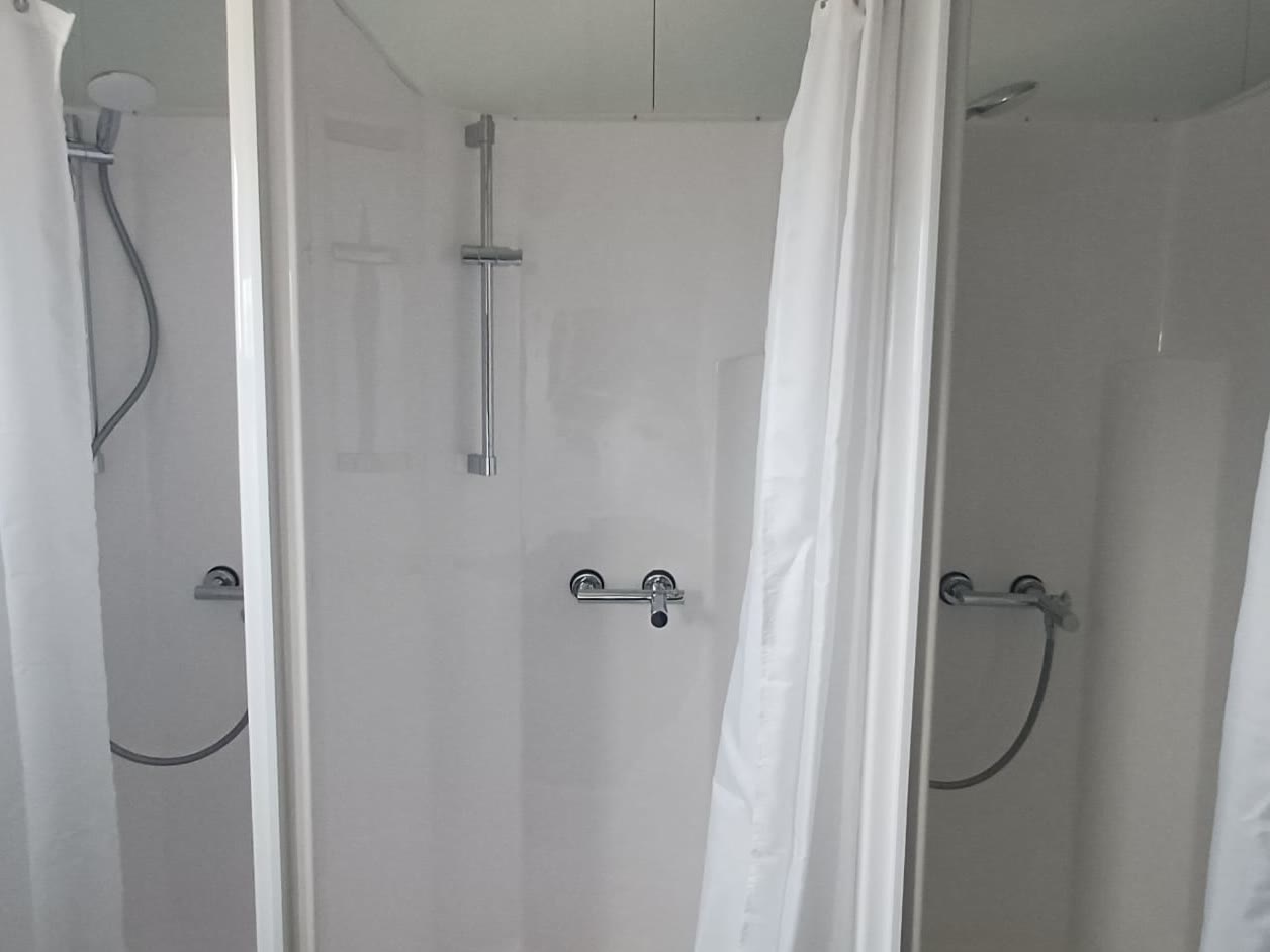 Le docce dell'area, tre box con tenda, puliti